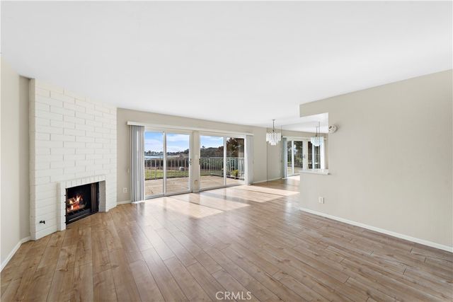 a view of empty room with wooden floor and fireplace