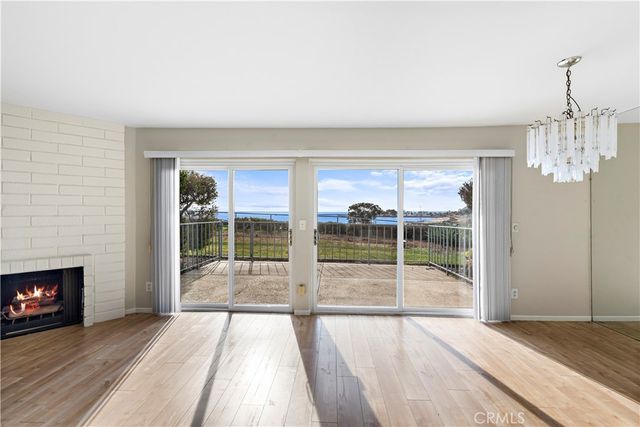 a view of empty room with wooden floor and fireplace