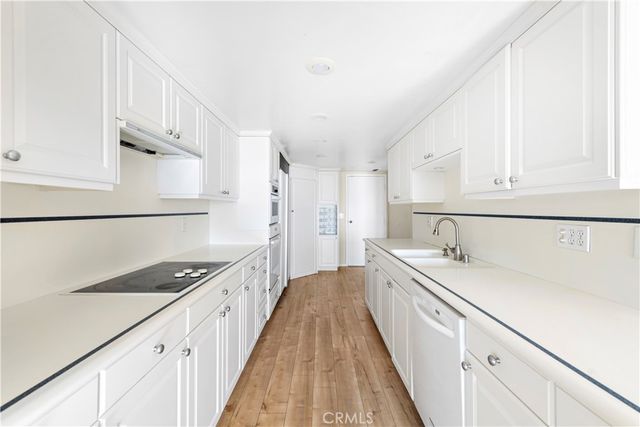 a kitchen with granite countertop a sink a stove and refrigerator