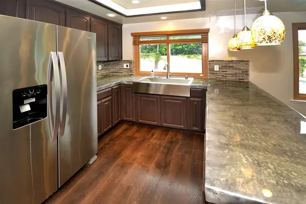 a kitchen with granite countertop a refrigerator and a sink