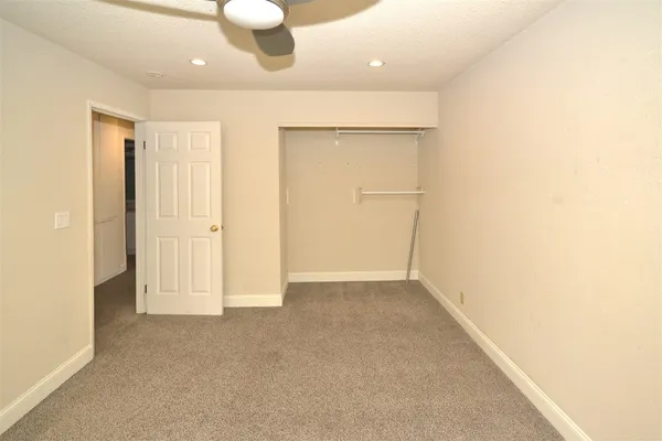 an empty room with windows and cabinet