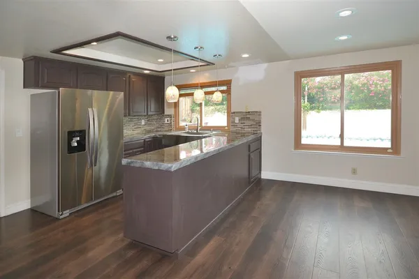a kitchen with stainless steel appliances granite countertop a refrigerator and a sink