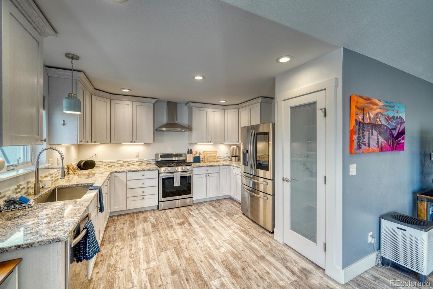 148 Grouse Road Buena Vista, CO 81211 - Photo 14 of 37 a large kitchen with stainless steel appliances granite countertop a refrigerator oven a sink dishwasher and white cabinets with wooden floor