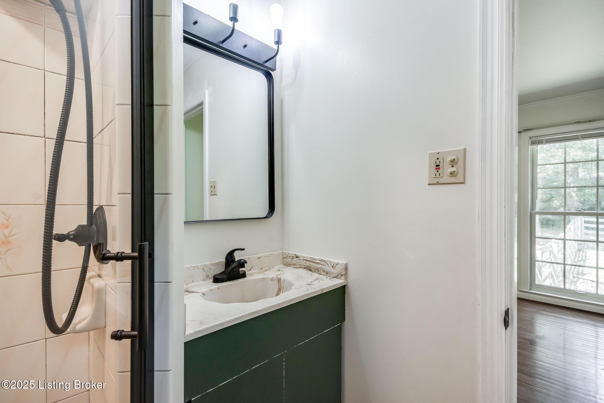9611 Fairground Road Louisville, KY 40291 - Photo 25 of 57 Primary Bathroom with tile flooring, new toilet, new shower door, new light fixture, tiled walk-in shower, new faucet and half smoke glass window.