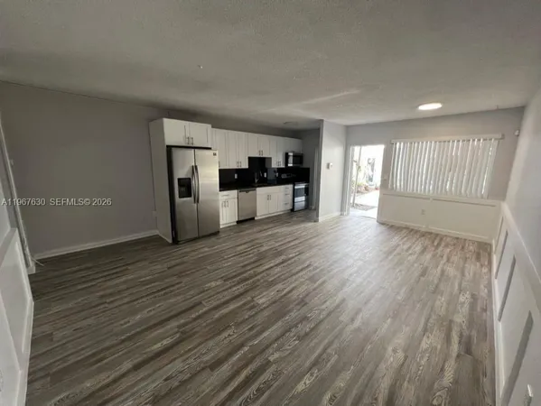 a view of a kitchen with wooden floor and electronic appliances