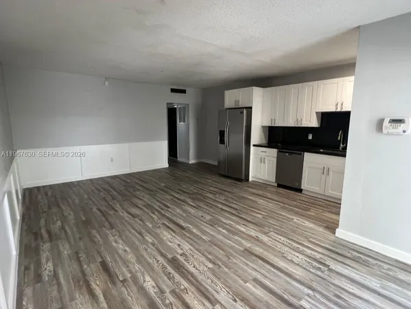 a view of a kitchen with a sink and a refrigerator