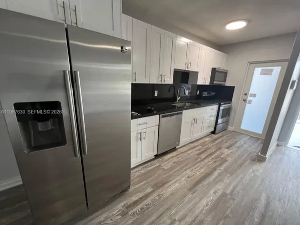 a kitchen with stainless steel appliances a refrigerator sink and microwave