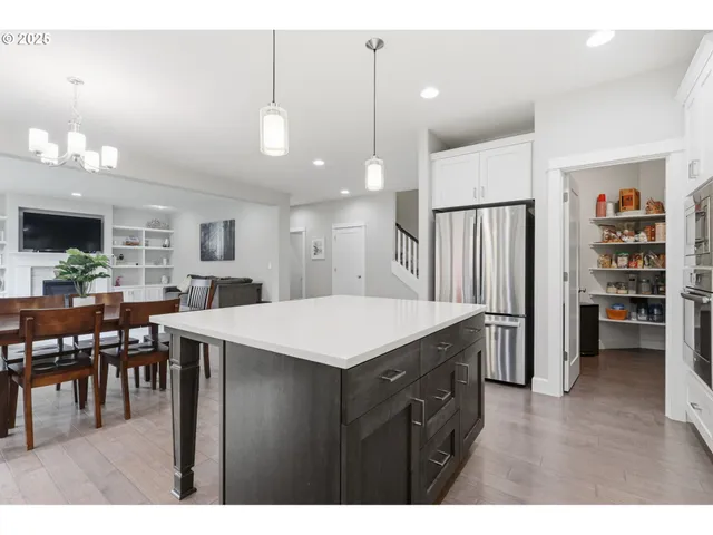 a kitchen with a table chairs refrigerator and cabinets