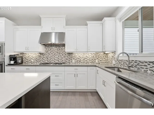 a kitchen with stainless steel appliances granite countertop a sink stove and cabinets