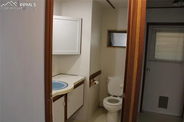 a bathroom with a granite countertop toilet and a sink