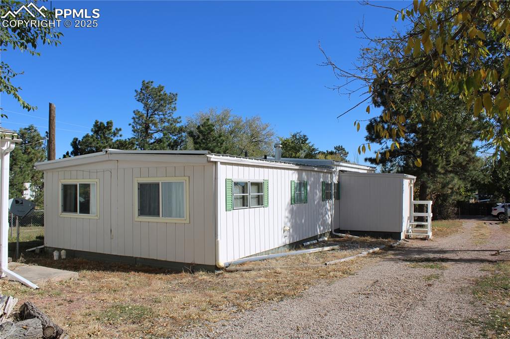 8320 Piute Road Colorado Springs, CO 80926 - Photo 4 of 20 a view of a white house with a yard and garage