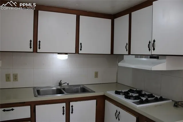 a kitchen with a sink cabinets and stove top oven
