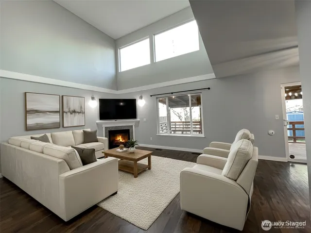 a living room with furniture a fireplace and a large window