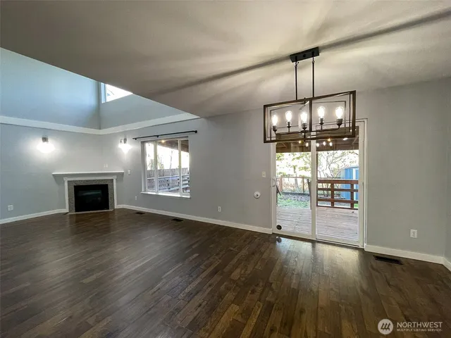 a view of empty room with wooden floor and fireplace