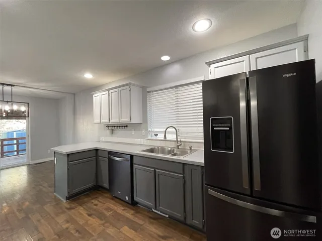 a kitchen with stainless steel appliances granite countertop a refrigerator and a sink