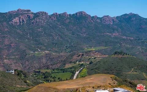 an aerial view of ocean with trees