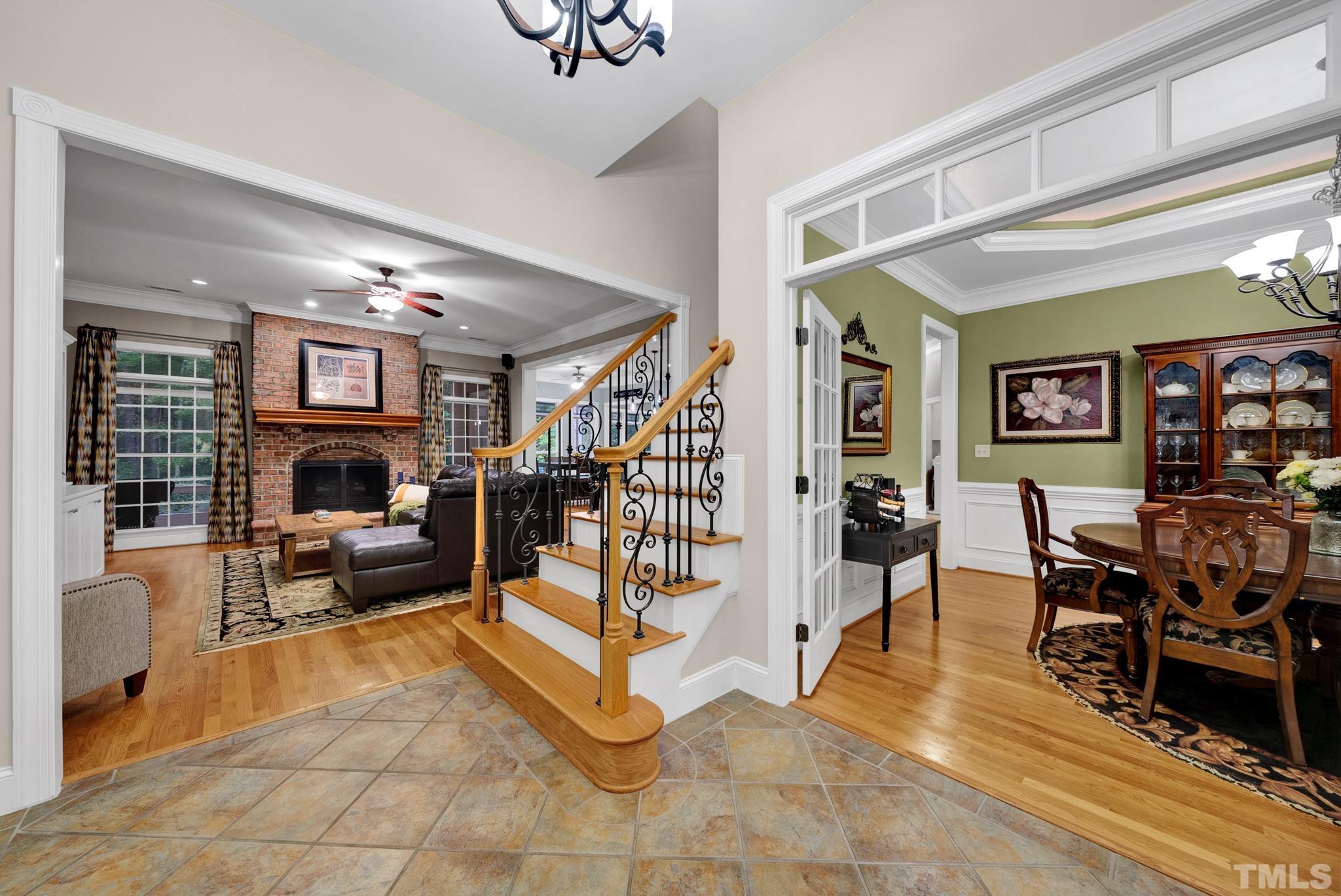 3249 Grand Oak Lane New Hill, NC 27562 - Photo 13 of 65 a living room with furniture a fireplace and a chandelier