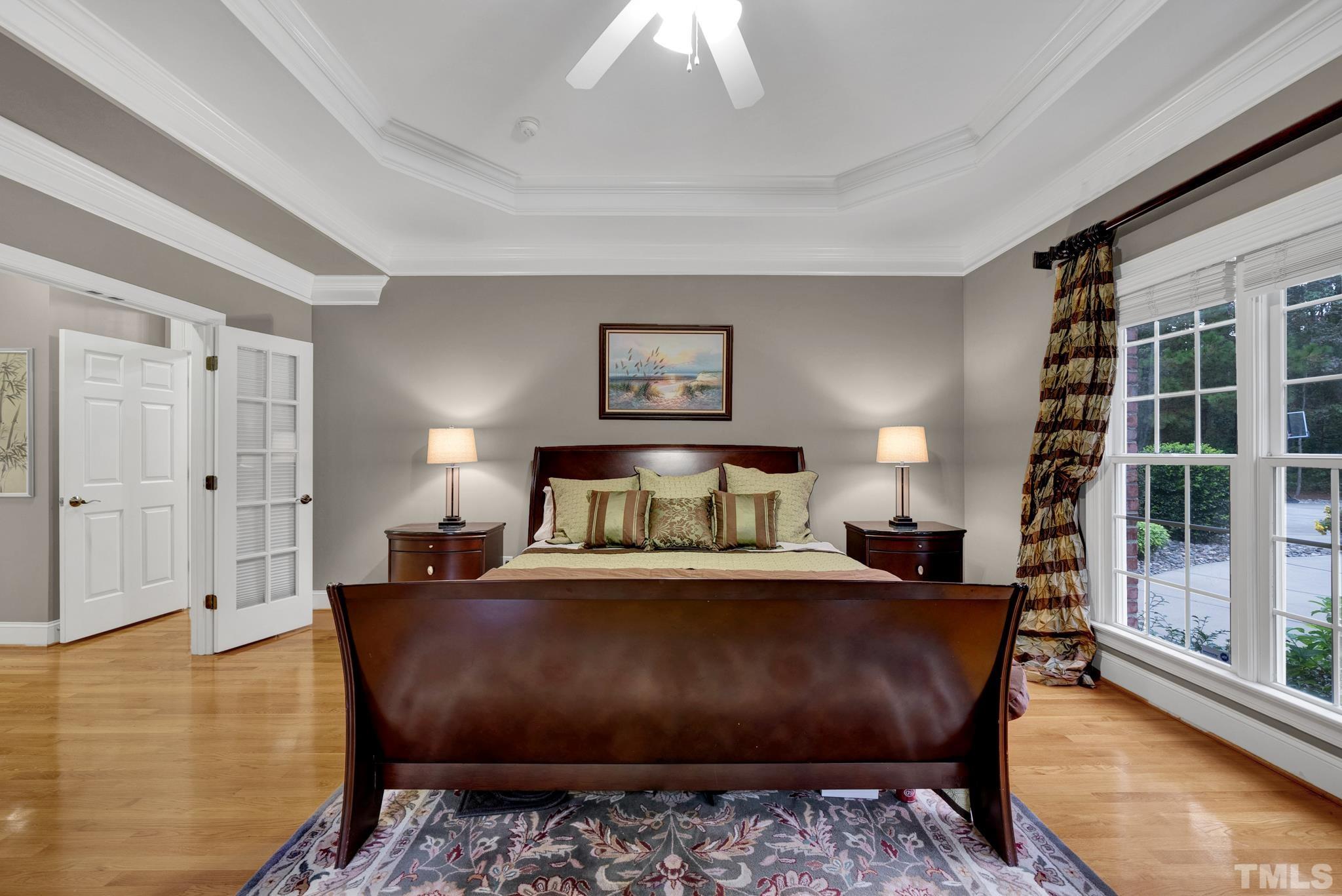 3249 Grand Oak Lane New Hill, NC 27562 - Photo 23 of 65 a bedroom with a large bed and a chandelier