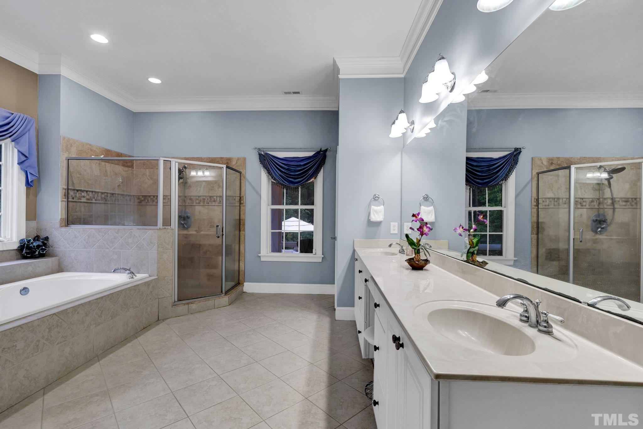 3249 Grand Oak Lane New Hill, NC 27562 - Photo 24 of 65 a spacious bathroom with a double vanity sink a large mirror and a shower