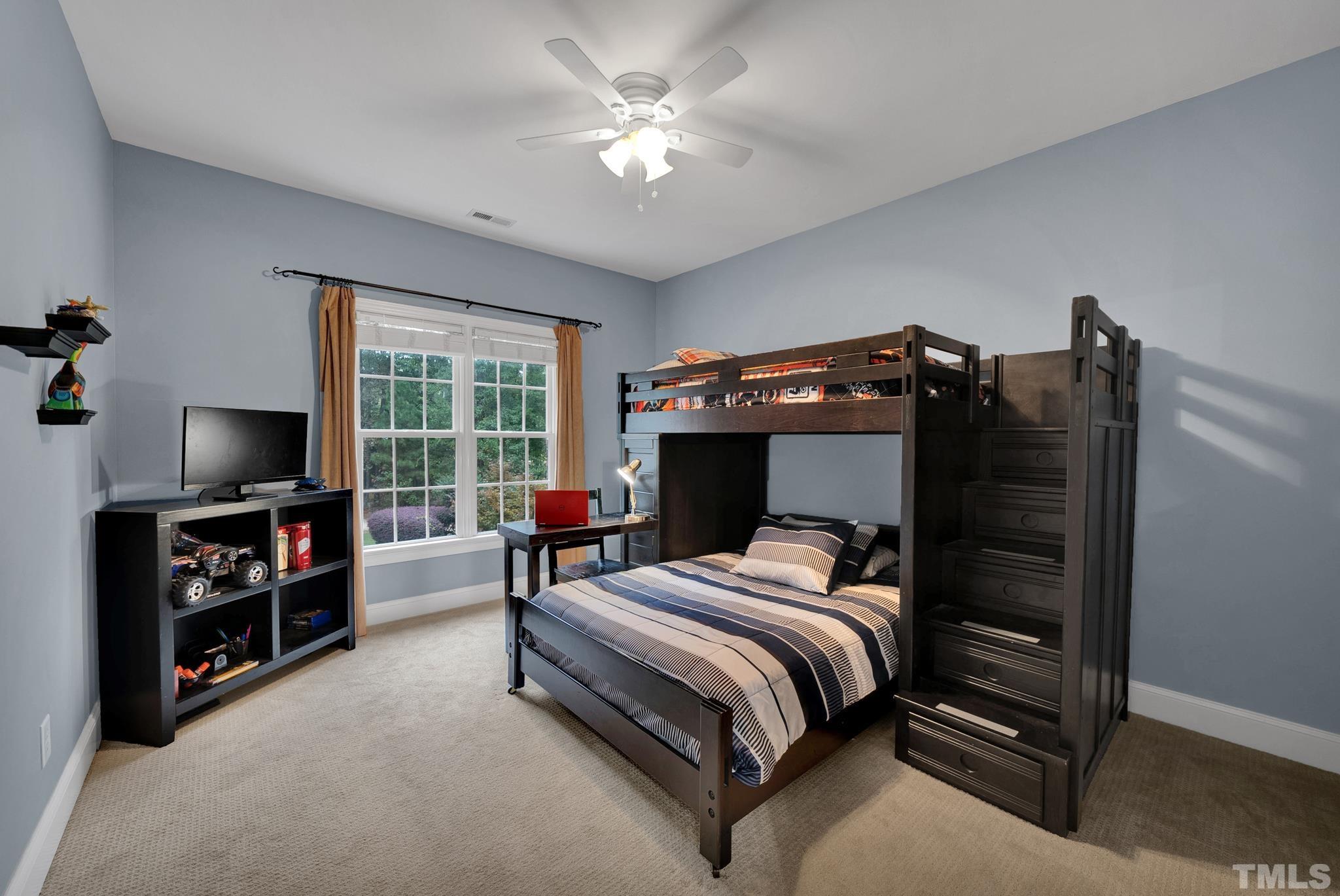 3249 Grand Oak Lane New Hill, NC 27562 - Photo 29 of 65 a bedroom with a bed and a flat tv screen on the dresser
