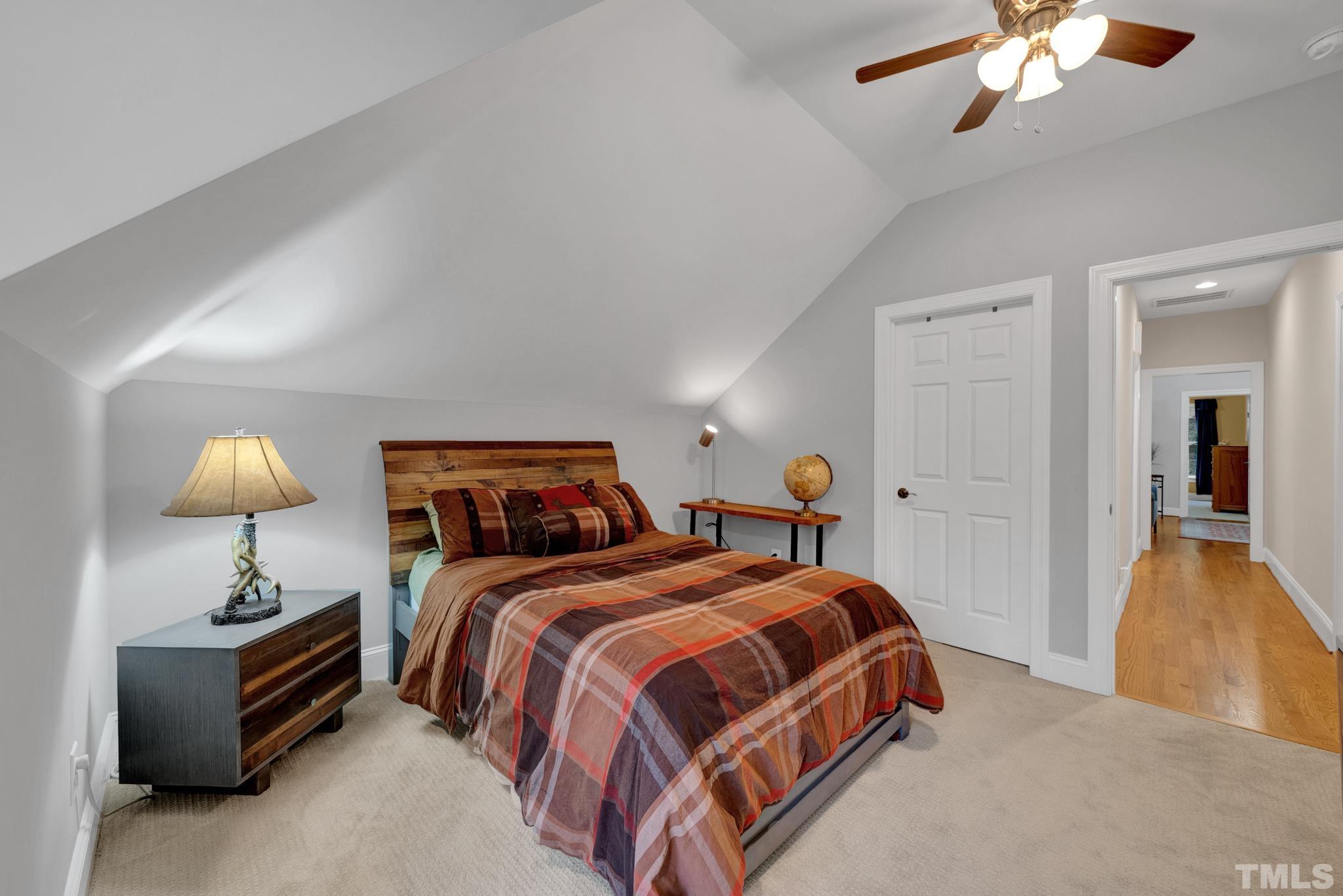 3249 Grand Oak Lane New Hill, NC 27562 - Photo 32 of 65 a bedroom with bed and a chandelier