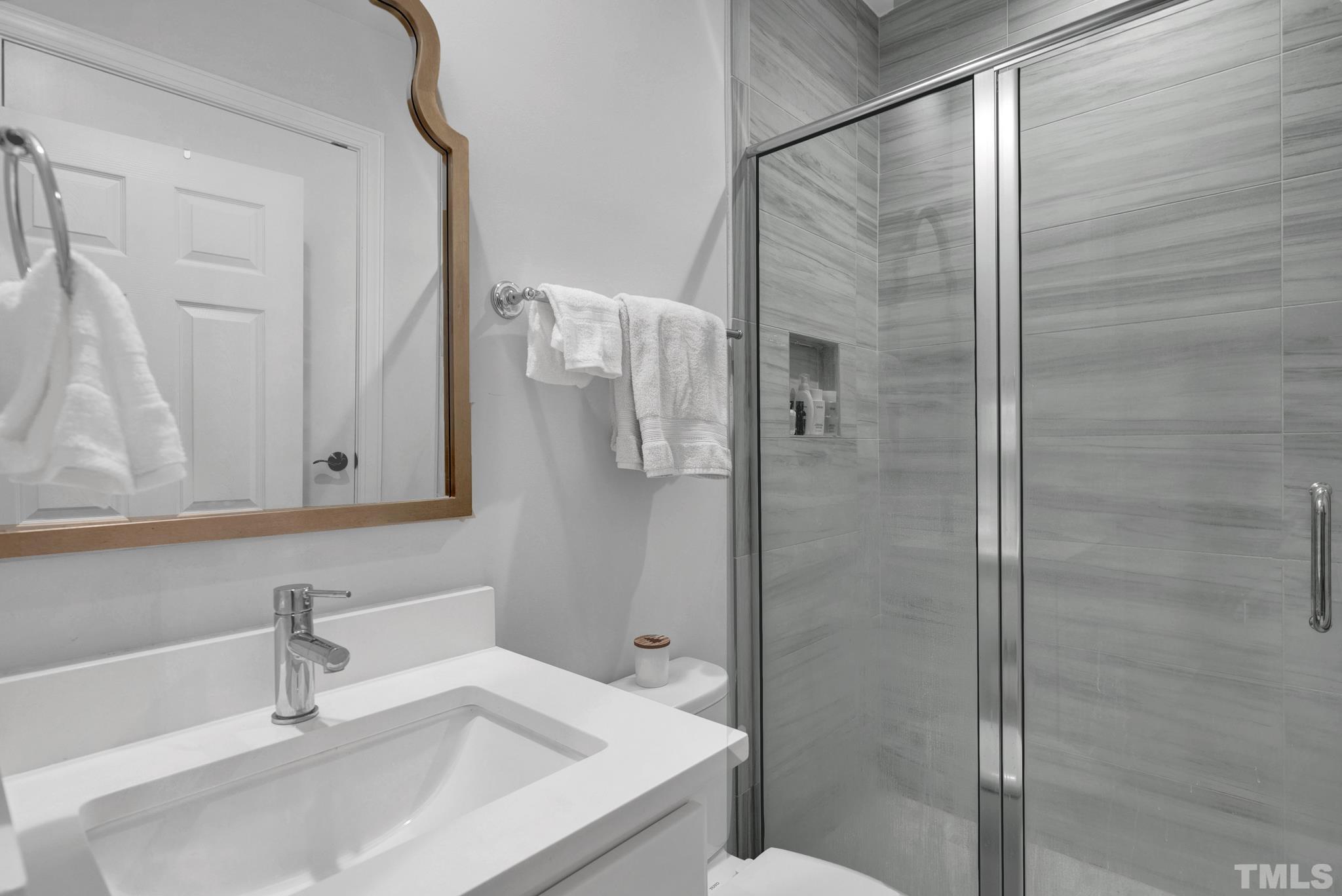 3249 Grand Oak Lane New Hill, NC 27562 - Photo 35 of 65 a bathroom with a sink and a mirror