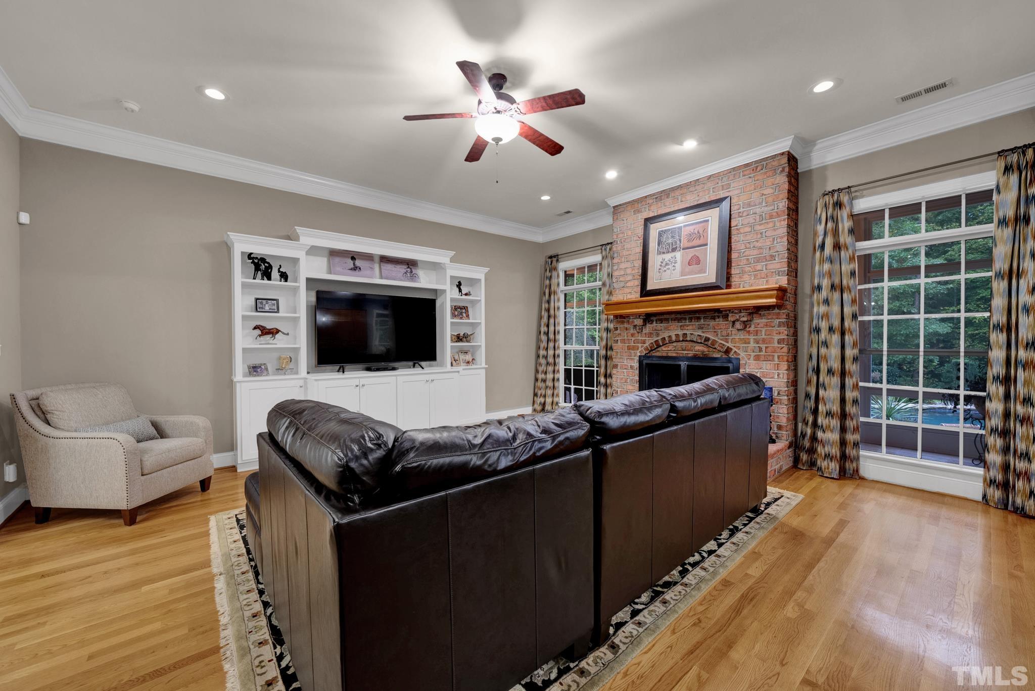 3249 Grand Oak Lane New Hill, NC 27562 - Photo 55 of 65 a living room with furniture a flat screen tv and a fireplace