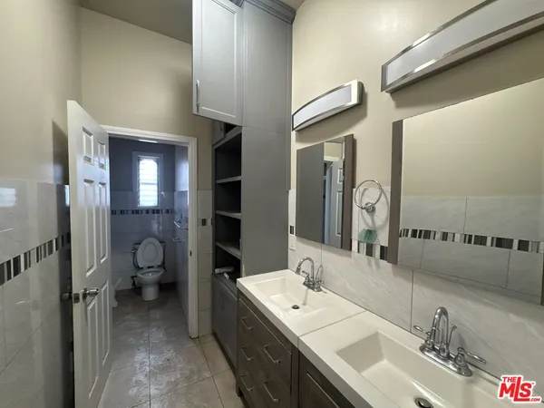 a bathroom with a double vanity sink and a mirror