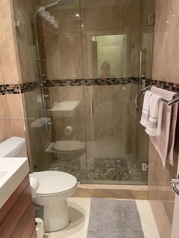 a bathroom with a sink a toilet and shower