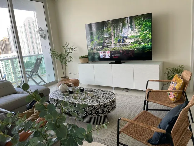 a living room with furniture and a floor to ceiling window