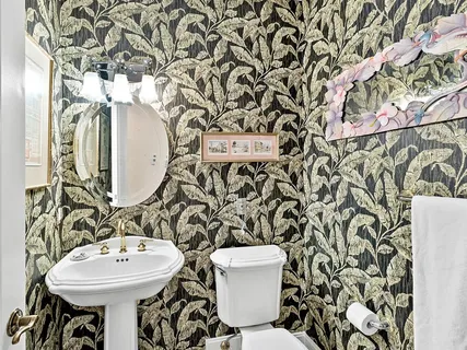 a bathroom with a toilet sink and mirror