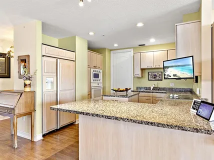 a kitchen with stainless steel appliances granite countertop a sink a stove and a refrigerator