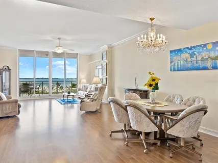 a view of a dining room with furniture a chandelier and wooden floor