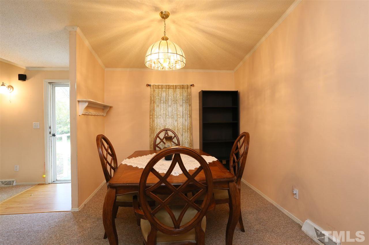 323 Aquilla Road, Unit A Benson, NC 27504 - Photo 17 of 25 a view of a dining room with furniture and a chandelier