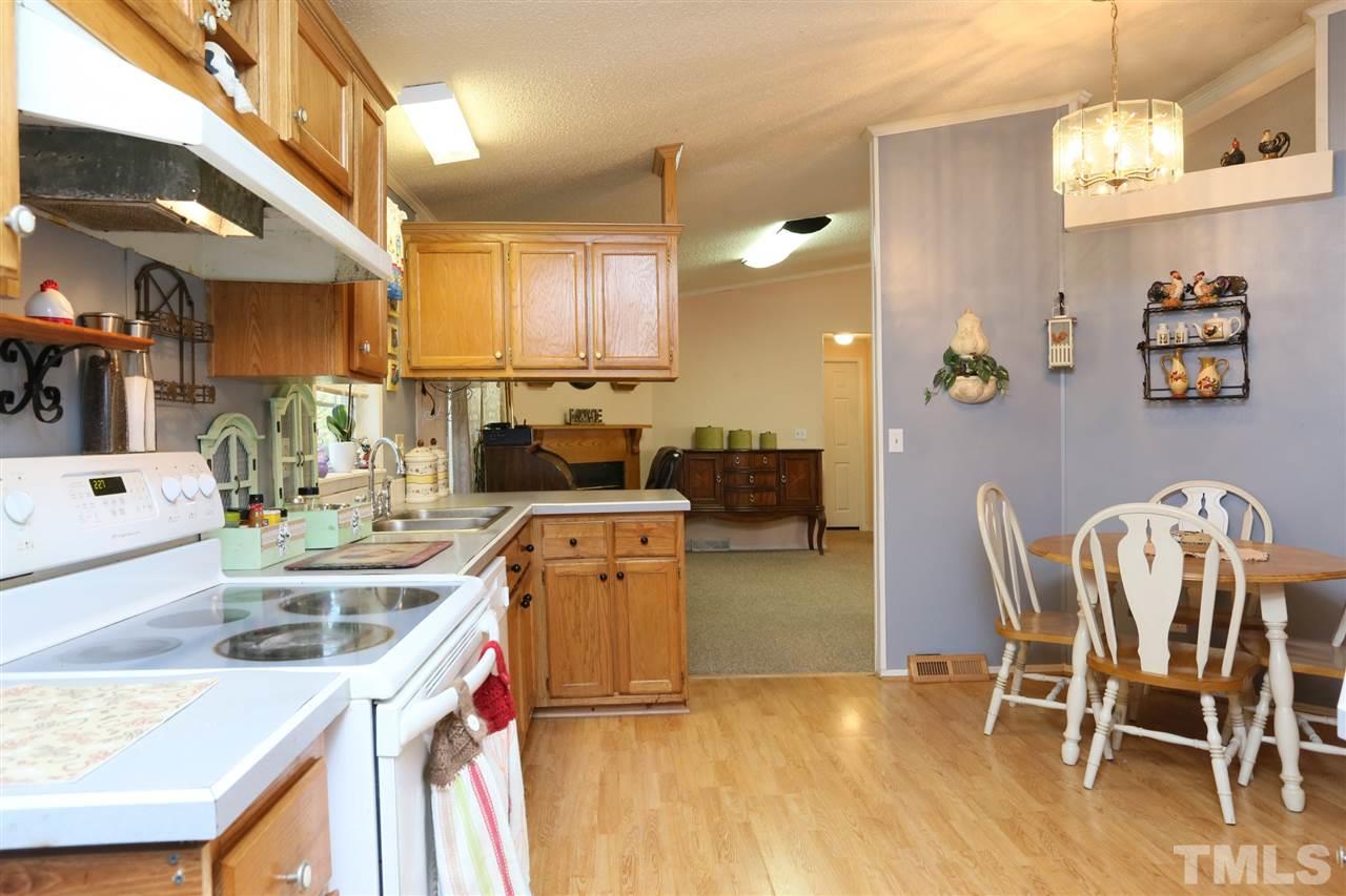 323 Aquilla Road, Unit A Benson, NC 27504 - Photo 18 of 25 a kitchen with stainless steel appliances granite countertop a dining table chairs stove and sink