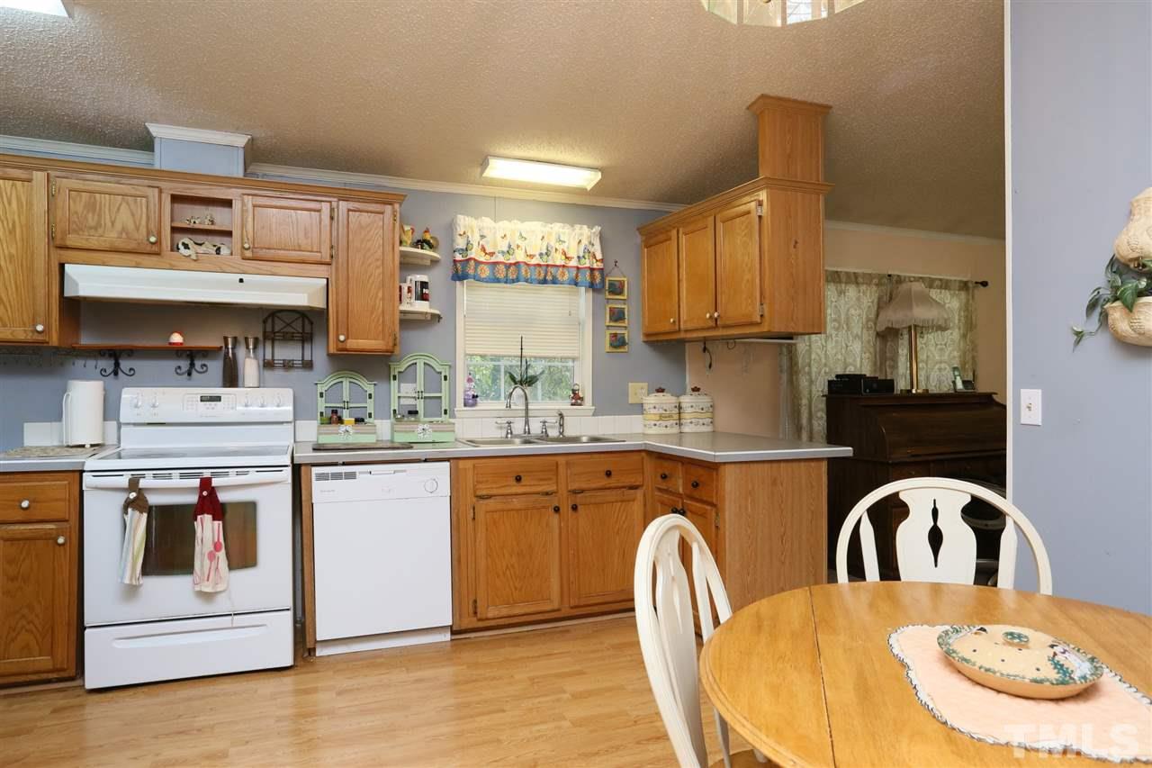 323 Aquilla Road, Unit A Benson, NC 27504 - Photo 19 of 25 a kitchen with stainless steel appliances granite countertop a stove a sink dishwasher and cabinets with wooden floor