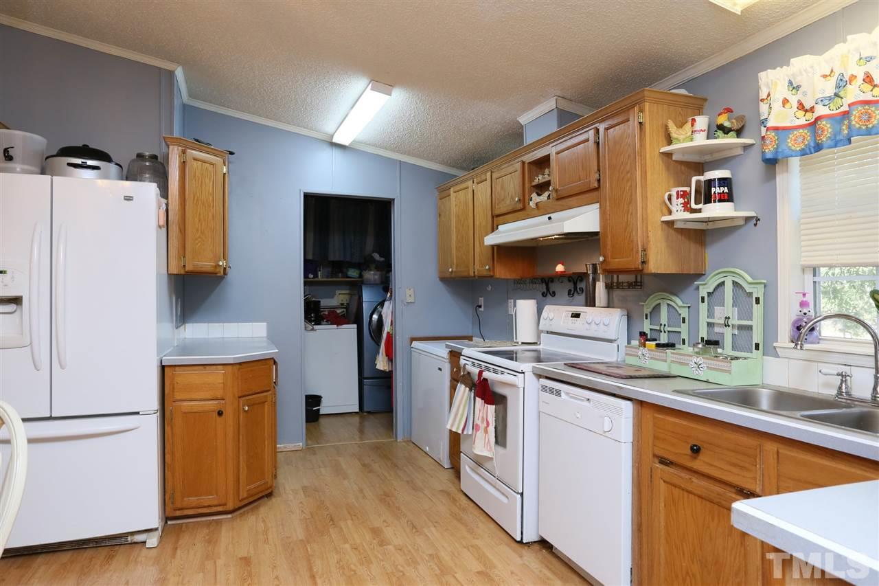 323 Aquilla Road, Unit A Benson, NC 27504 - Photo 21 of 25 a kitchen with a sink a refrigerator and wooden floor