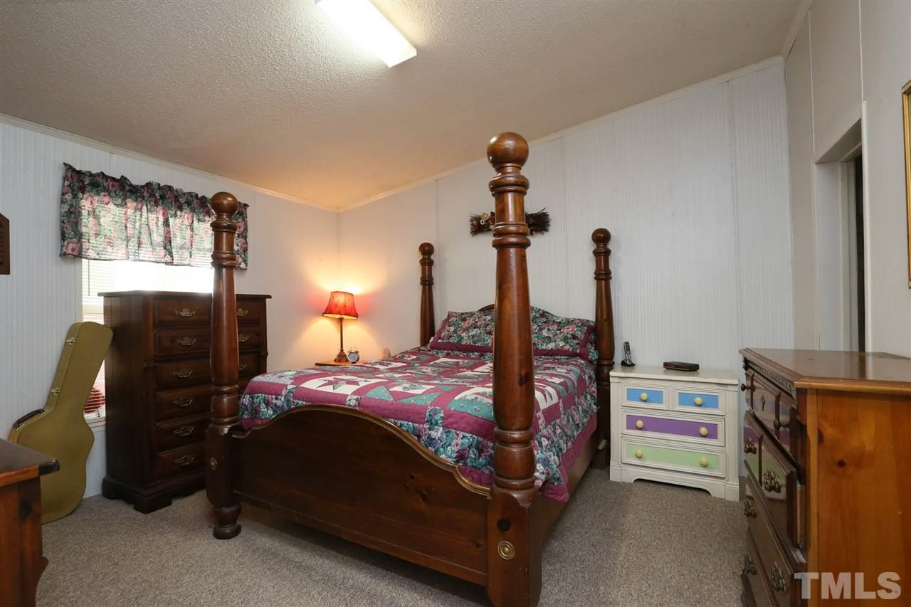 323 Aquilla Road, Unit A Benson, NC 27504 - Photo 22 of 25 a bedroom with a bed and a chandelier