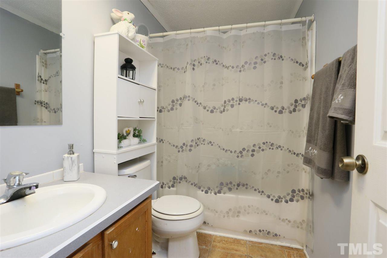 323 Aquilla Road, Unit A Benson, NC 27504 - Photo 25 of 25 a bathroom with a sink toilet a mirror and shower