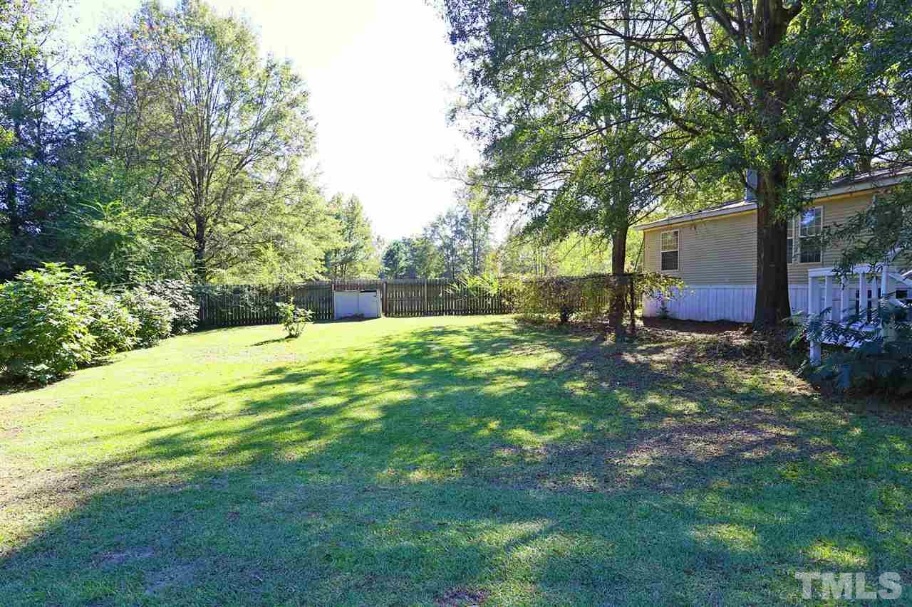 323 Aquilla Road, Unit A Benson, NC 27504 - Photo 5 of 25 a backyard of a house with table and chairs