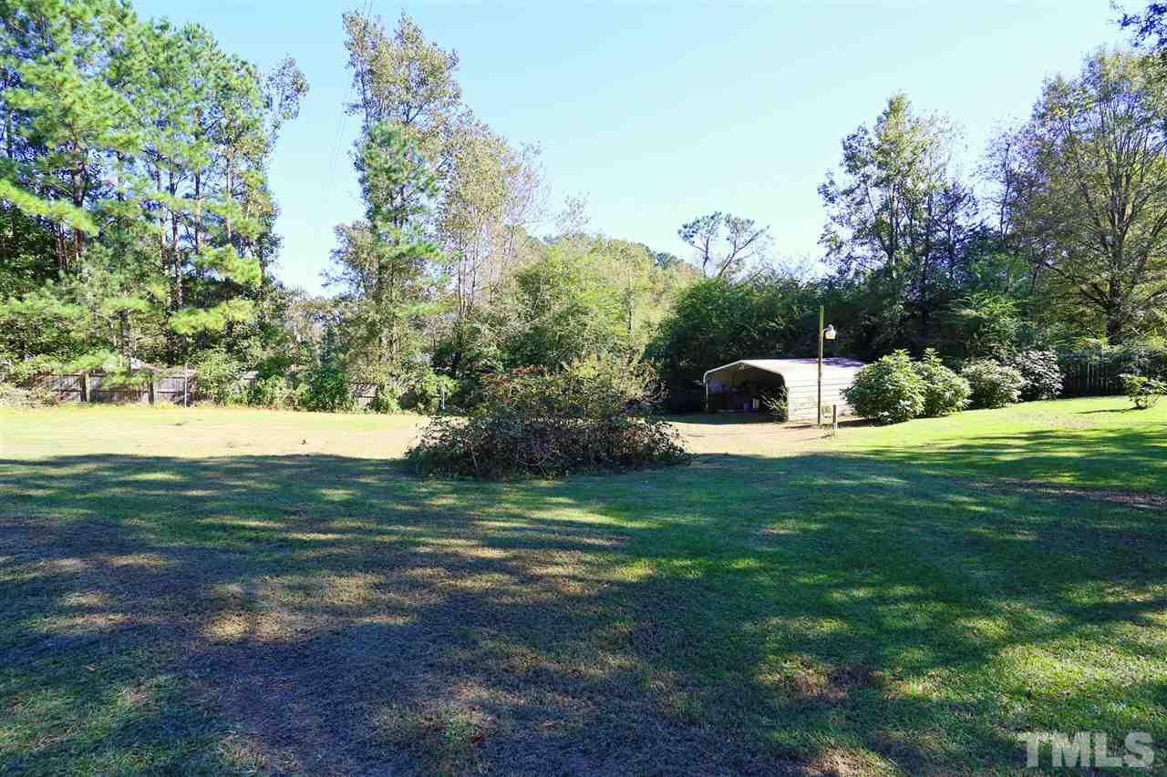 323 Aquilla Road, Unit A Benson, NC 27504 - Photo 6 of 25 a view of a yard with large trees