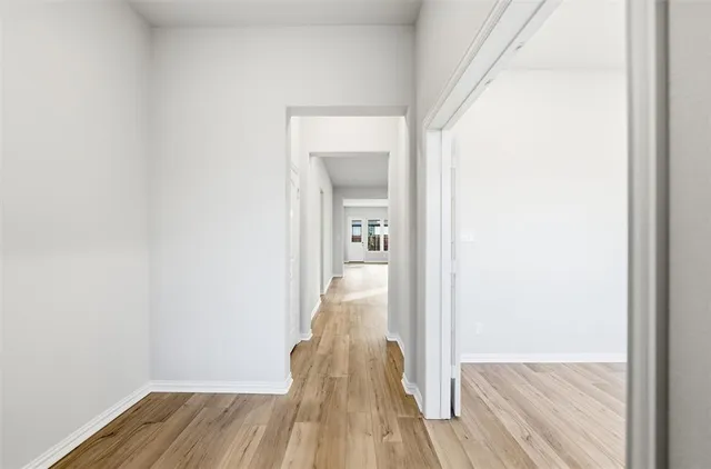 a view of a hallway with wooden floor