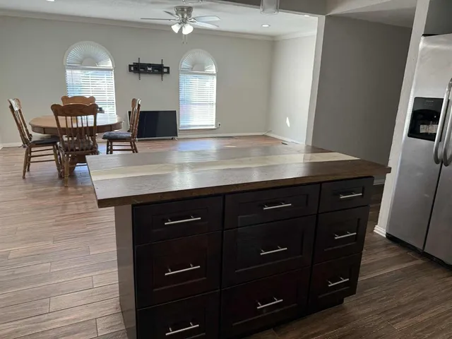a kitchen with a sink a counter space and wooden floor