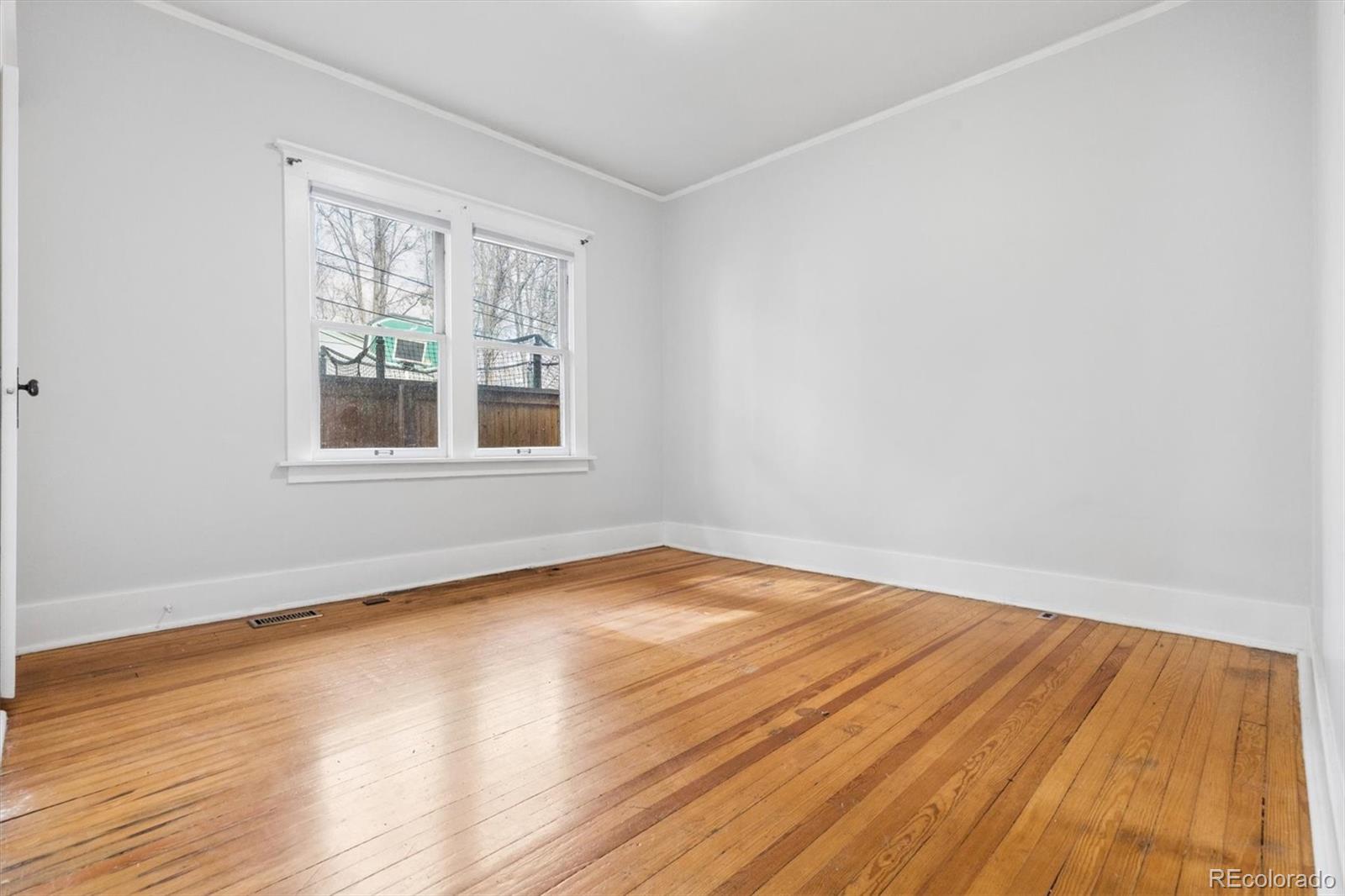 736 York Street Denver, CO 80206 - Photo 20 of 50 an empty room with wooden floor and windows