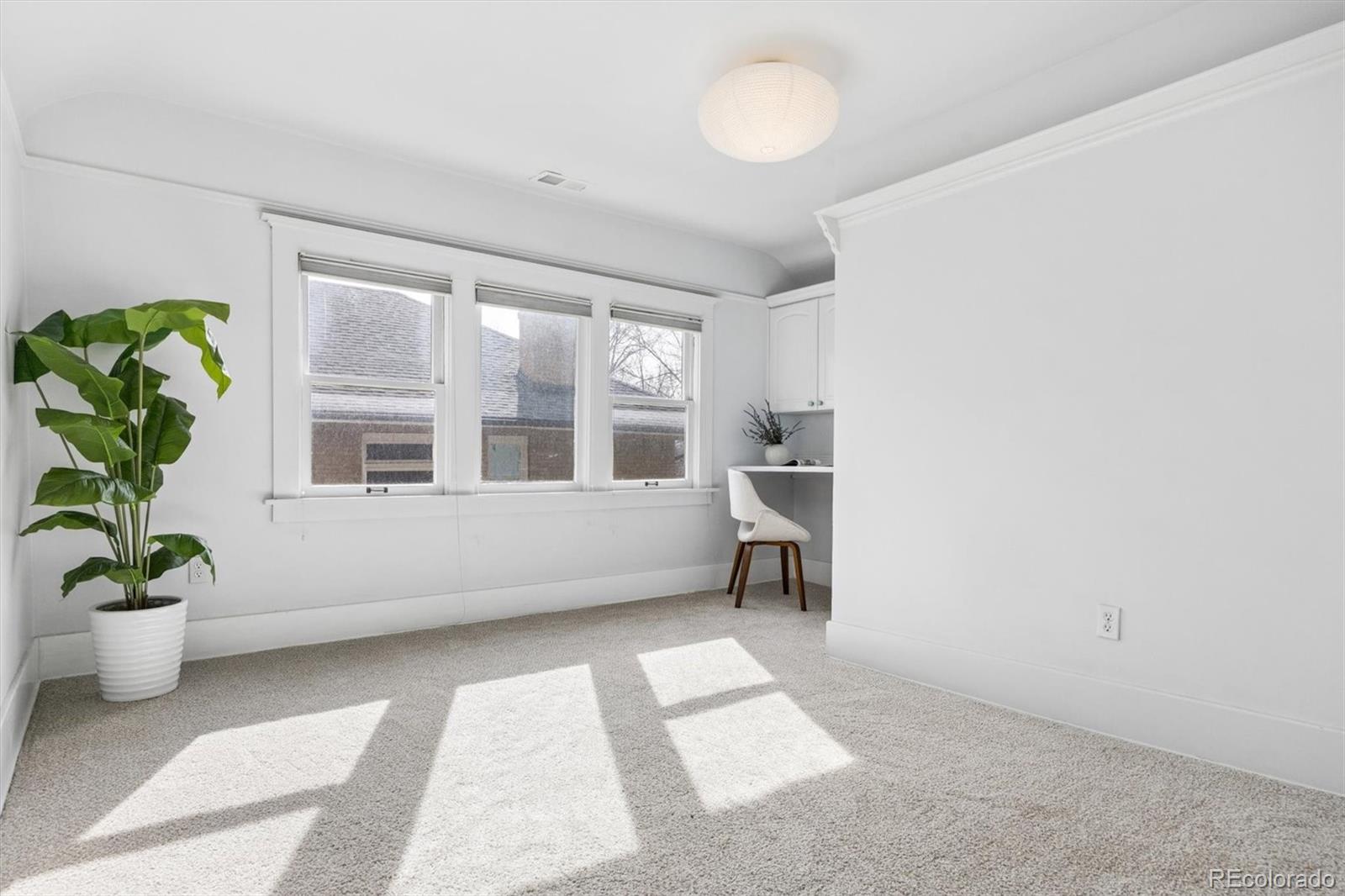 736 York Street Denver, CO 80206 - Photo 31 of 50 a view of an empty room with a window and wooden floor