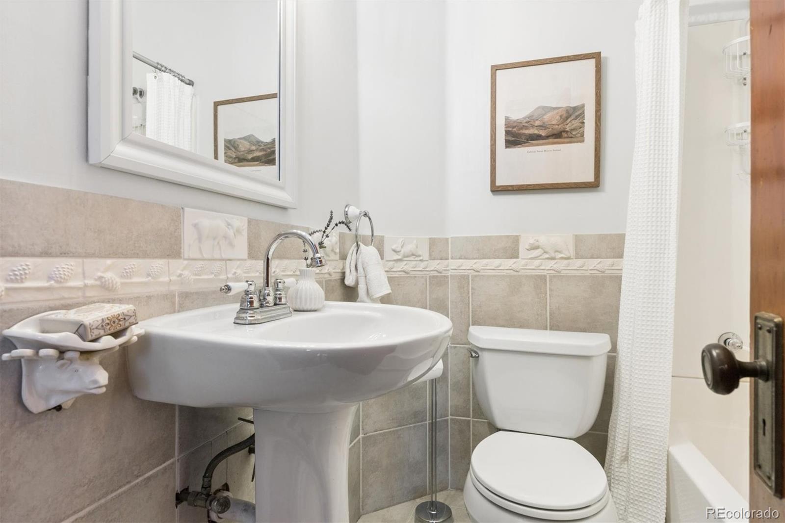 736 York Street Denver, CO 80206 - Photo 32 of 50 a bathroom with a toilet a sink and mirror