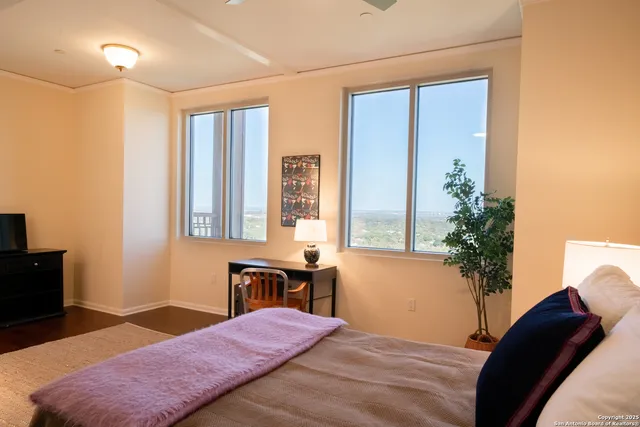 a bedroom with a bed table and a potted plant