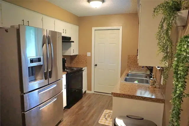 a kitchen with stainless steel appliances granite countertop a refrigerator and a stove