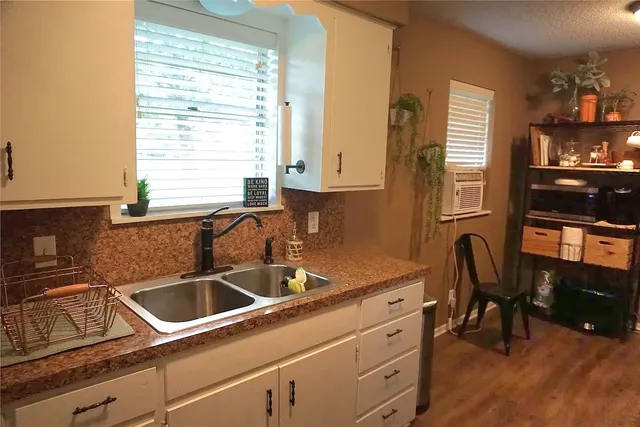 a kitchen with a sink cabinets and a large window