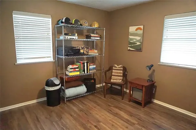 a living room with furniture and two window